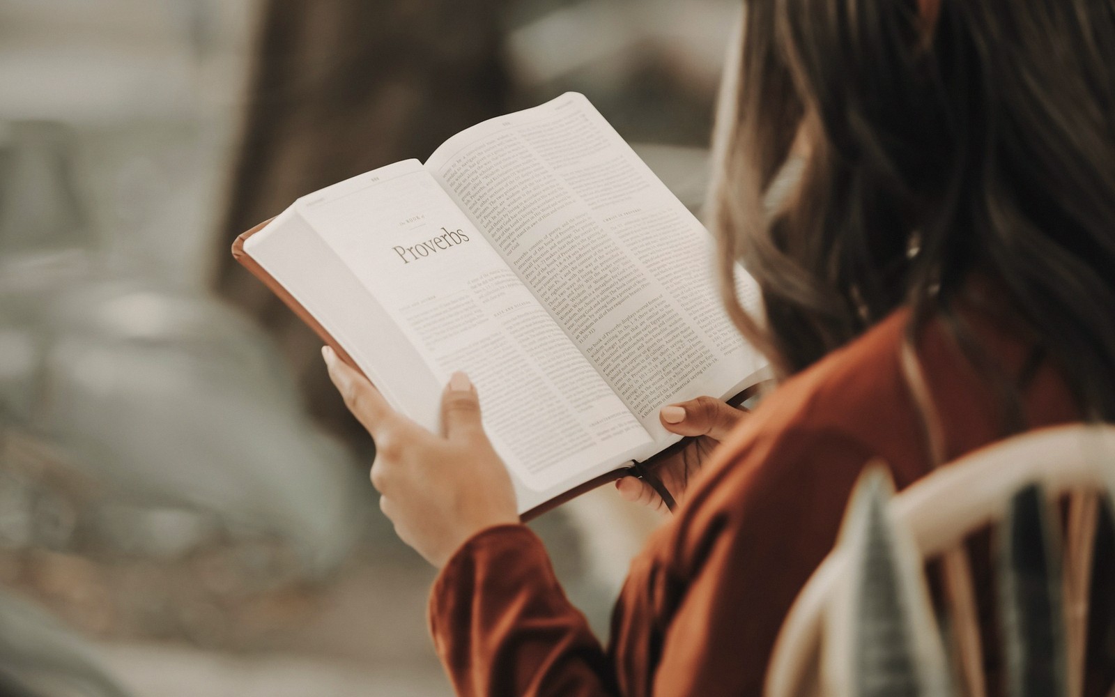 Woman reading an open Bible turned to the book of Proverbs